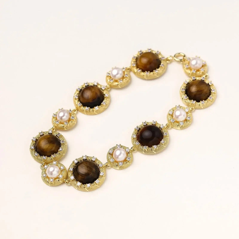 Gold-plated link bracelet with alternating brown tiger's eye stones and white freshwater pearls in ornate bezels.