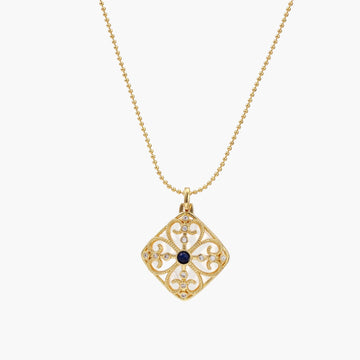 Gold filigree pendant with quatrefoil design, deep blue lapis lazuli center, clear crystal accents on ball chain